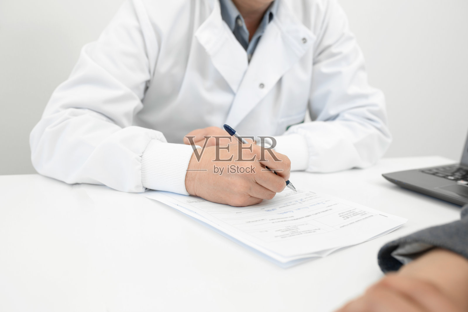 医生在病人病历上做记录照片摄影图片