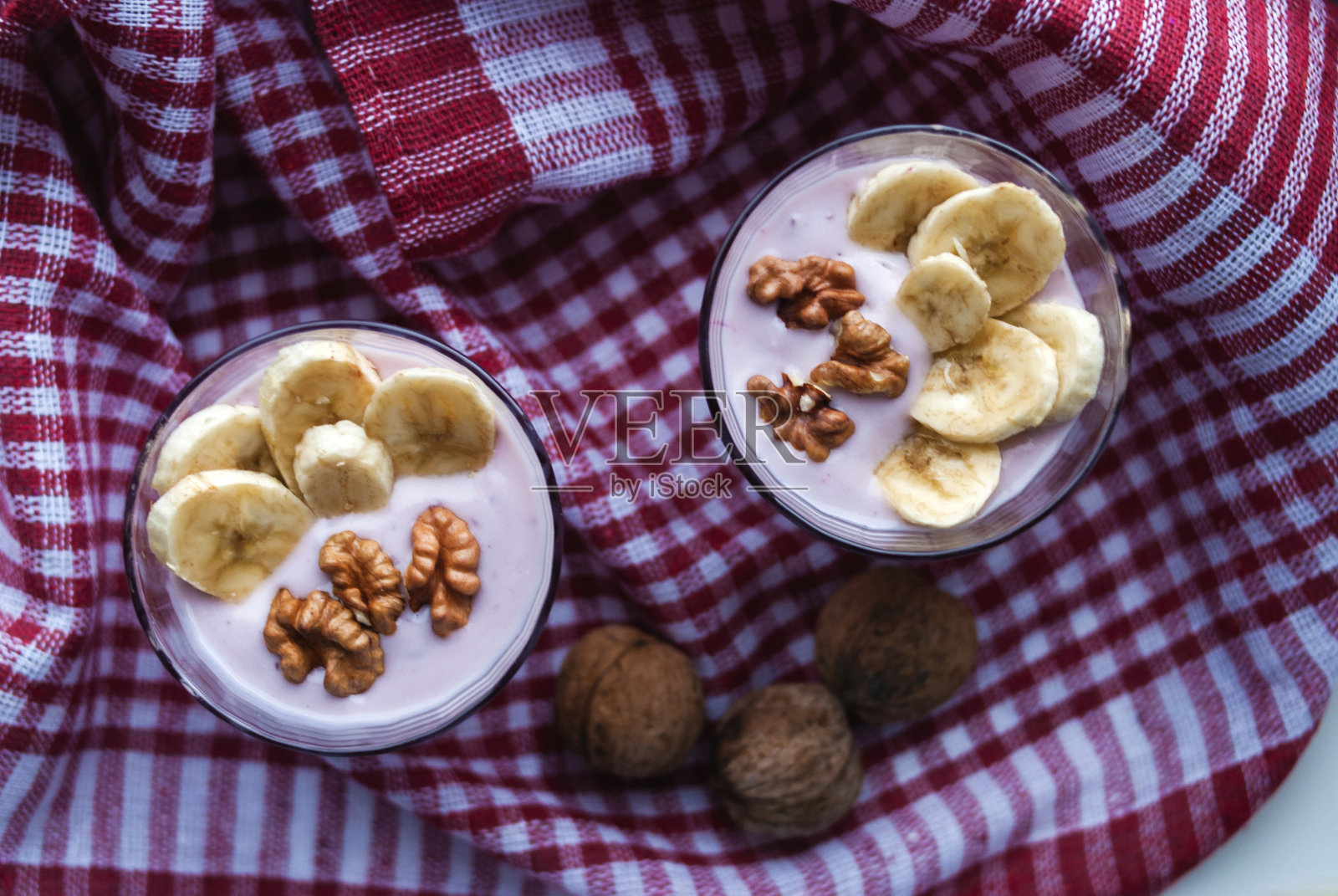 一杯含有蓝莓、麦片、香蕉和核桃的酸奶照片摄影图片