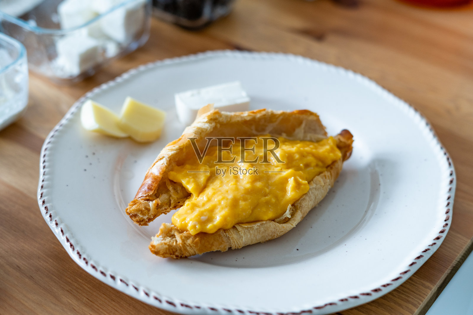 羊角面包夹炒鸡蛋的早餐。照片摄影图片