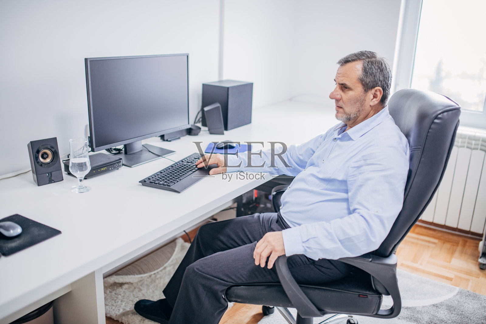 一位资深商人在办公室里使用电脑照片摄影图片