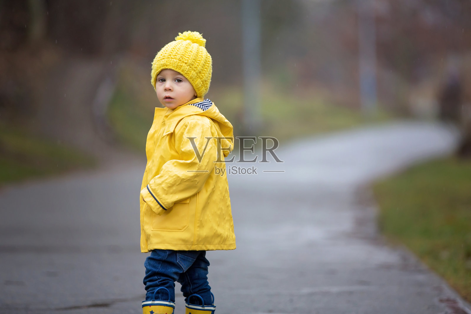 有趣的幼儿男孩在雨中玩耍照片摄影图片
