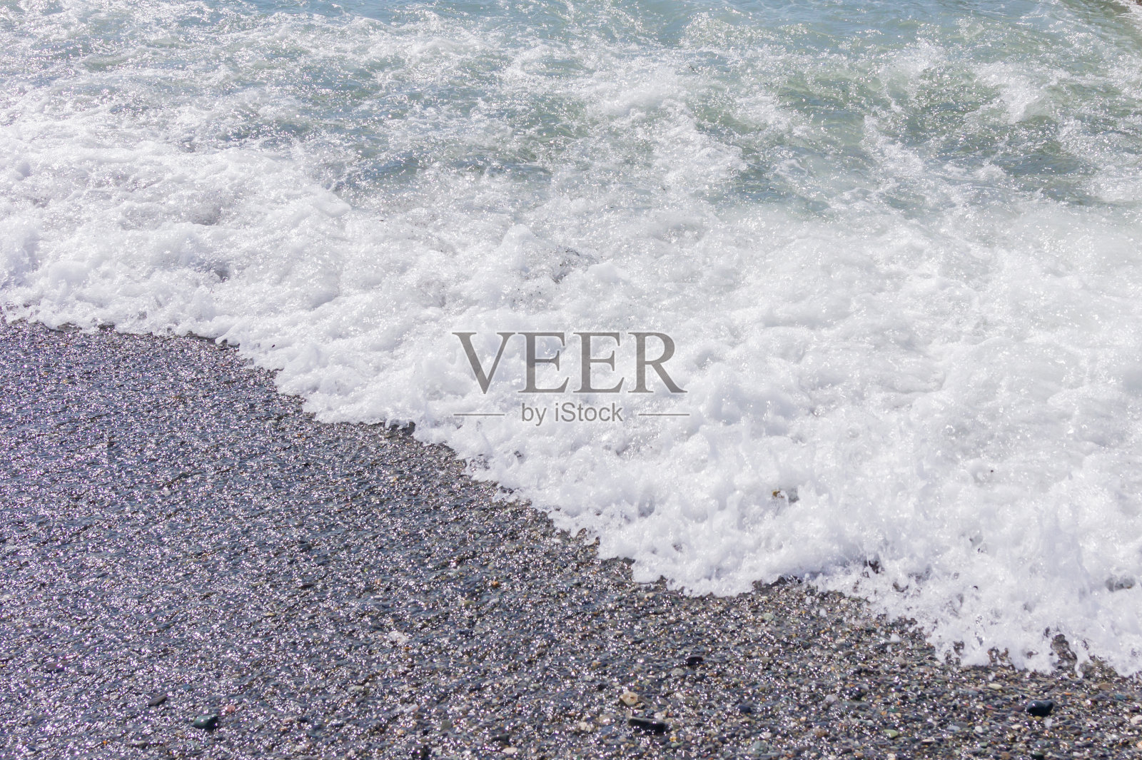 卵石海岸线。有透明的水和小石头的海滨照片摄影图片