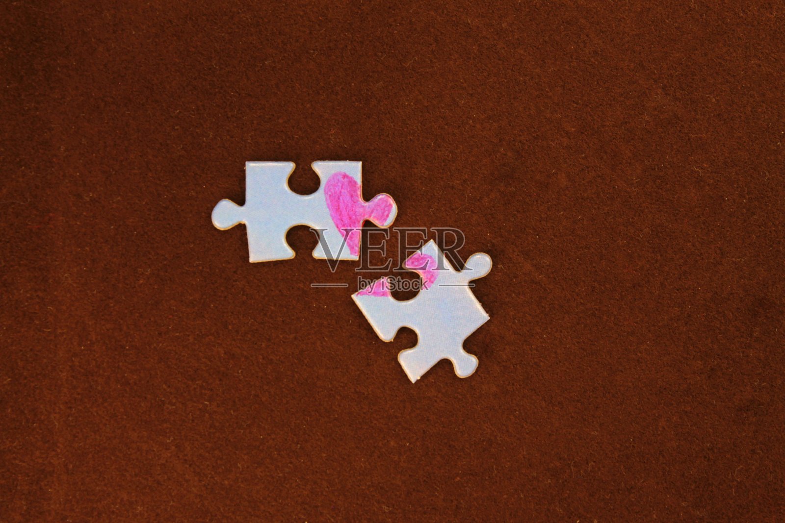 棕色背景上有一颗心的谜题。照片摄影图片