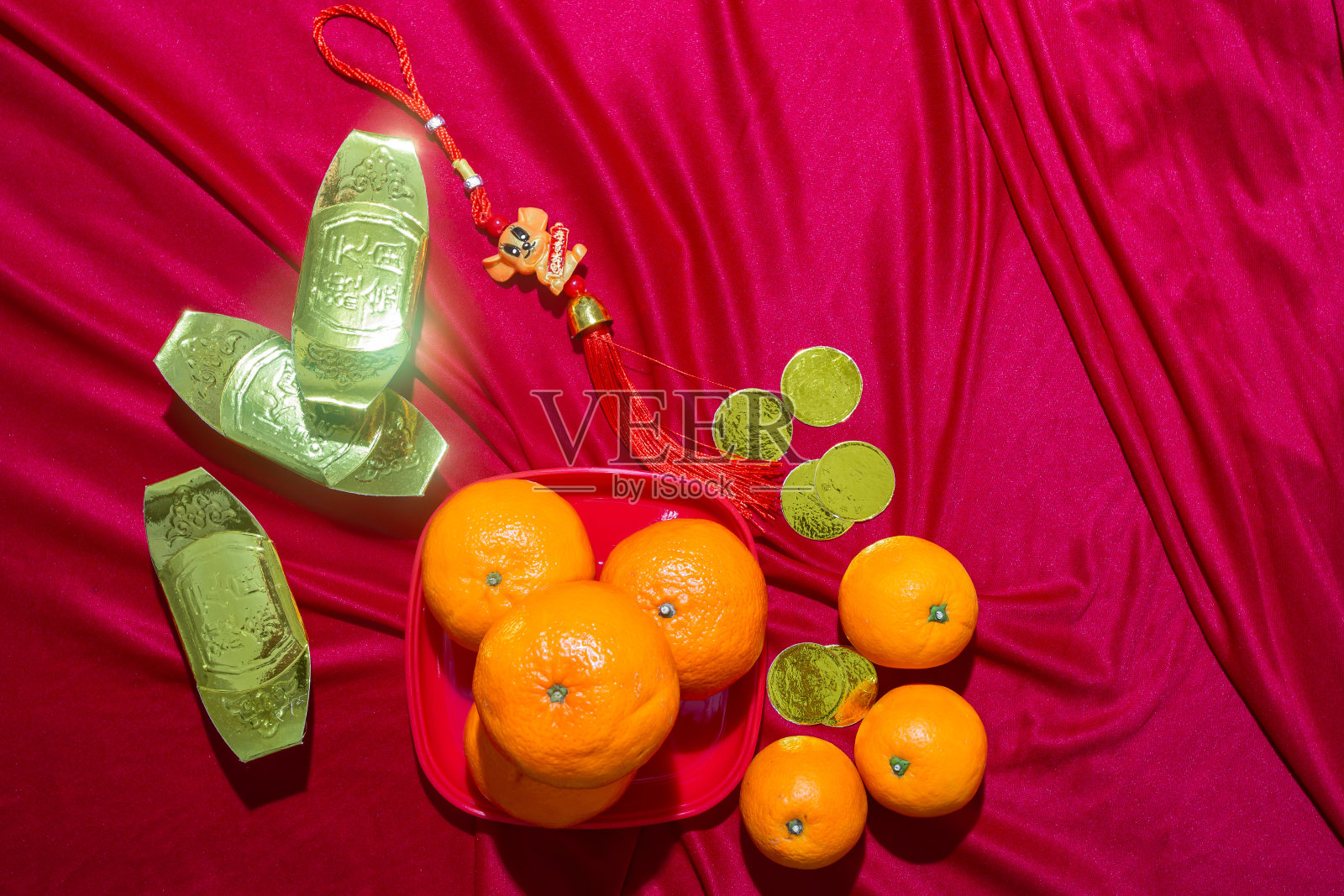 红色织物上的橘子和金色，中国新年照片摄影图片