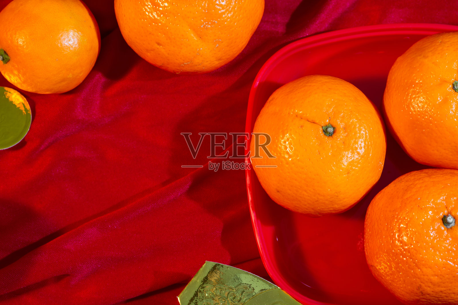 红色织物上的橘子和金色，中国新年照片摄影图片