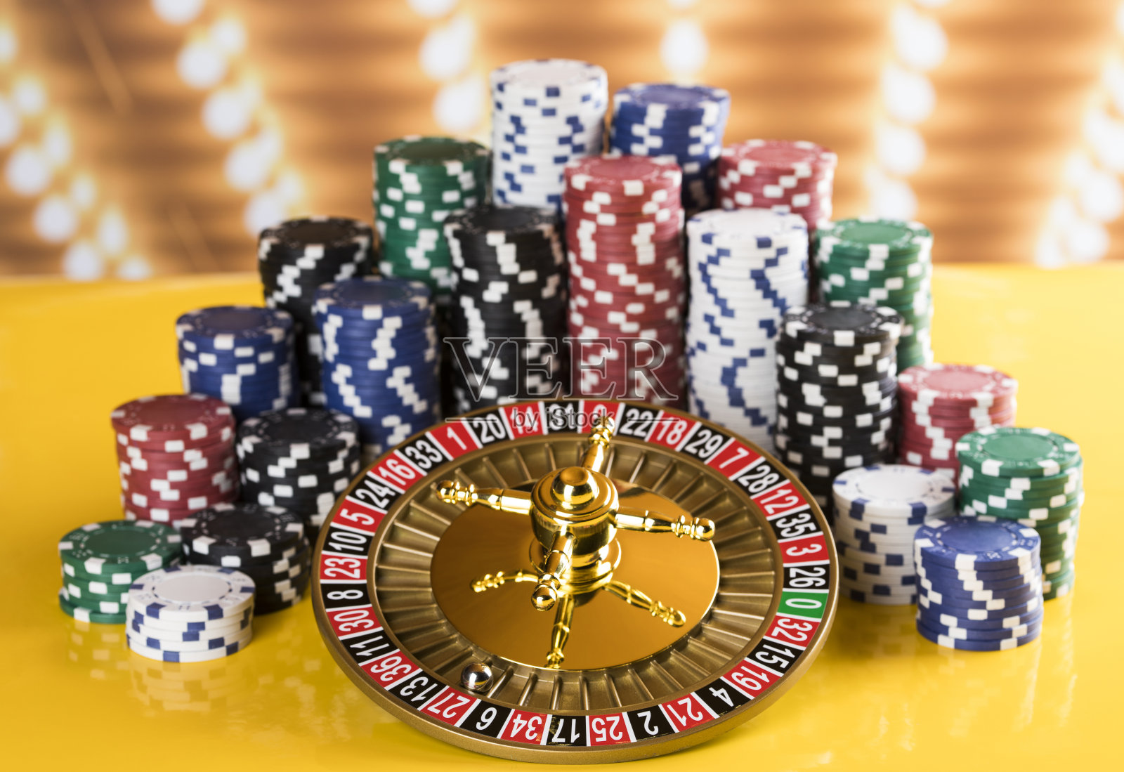 扑克筹码在游戏桌上，轮盘赌轮在运动，赌场背景照片摄影图片
