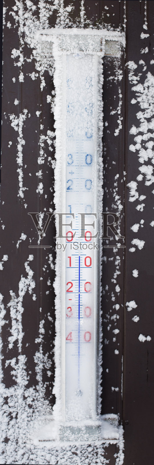 木制温度计在白雪覆盖的街道上照片摄影图片