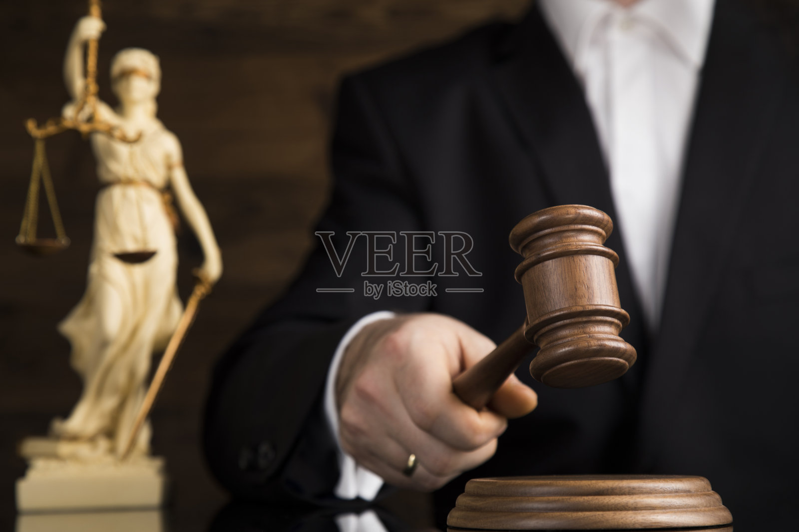 正义与法律概念：法庭上男法官敲击法槌照片摄影图片