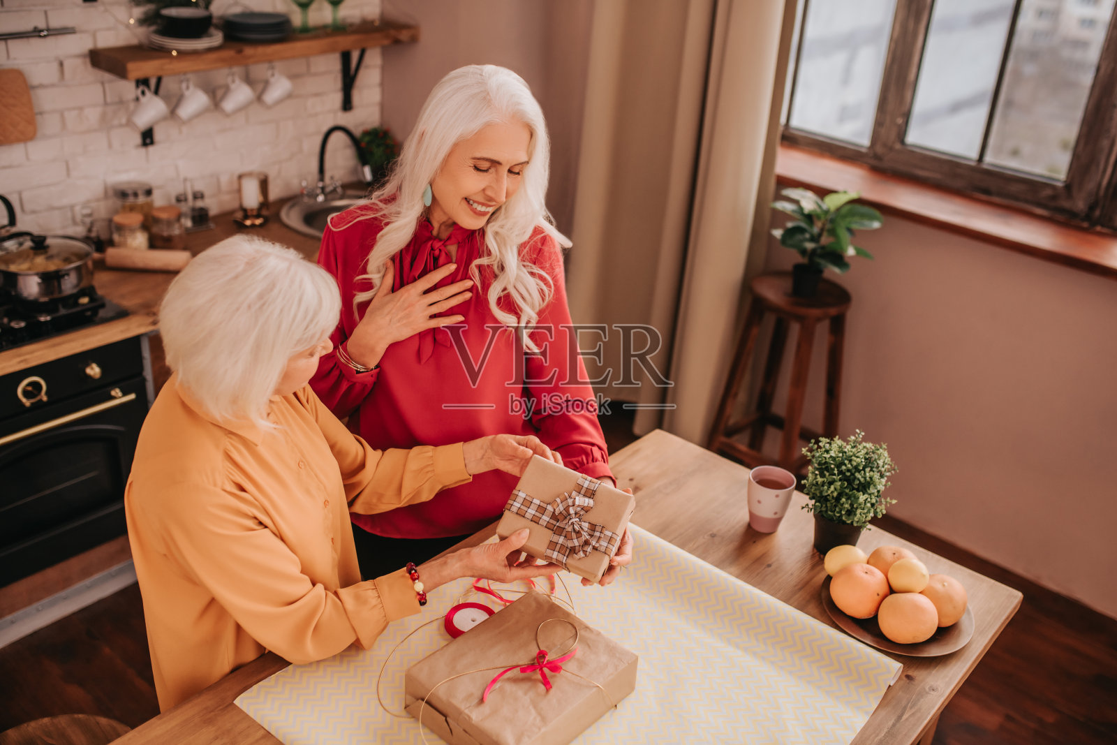 两位漂亮的老太太正在拆礼物照片摄影图片