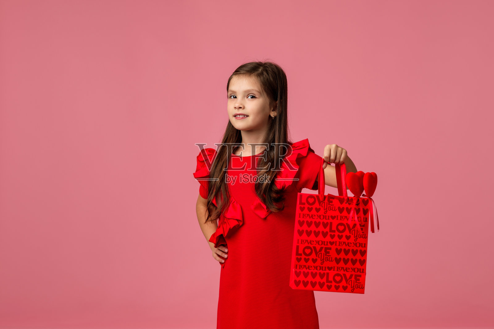 小女孩拿着红色纸质购物袋照片摄影图片