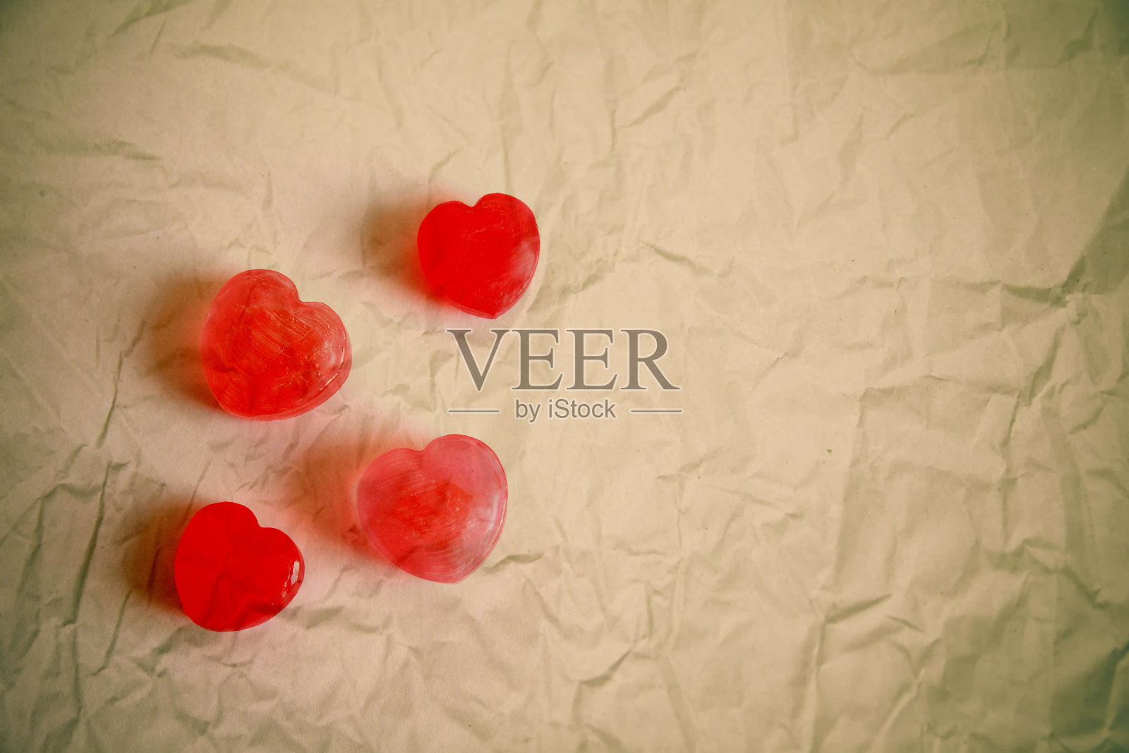 皱巴巴的纸上放着红心太妃糖照片摄影图片