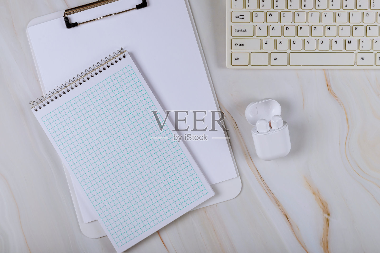 螺旋记事本在包装纸上无线耳机，电脑键盘照片摄影图片