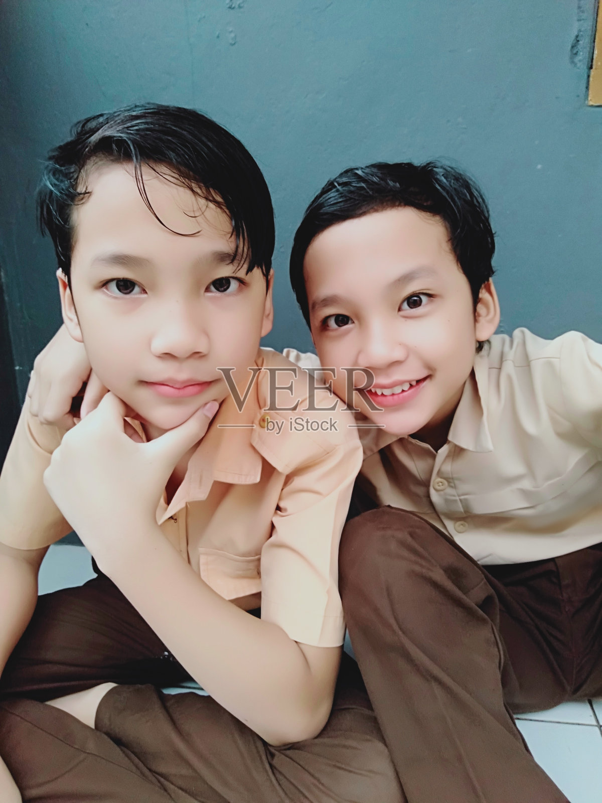 印度尼西亚学童穿着校服站在角落里。照片摄影图片