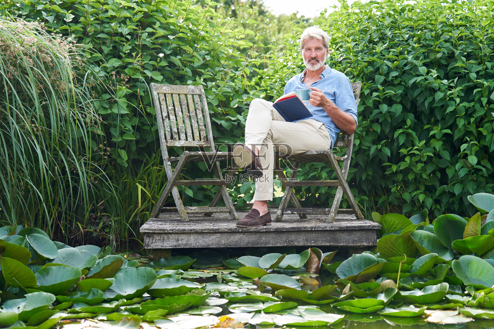 在湖边码头上看书放松的年长男人肖像照片摄影图片