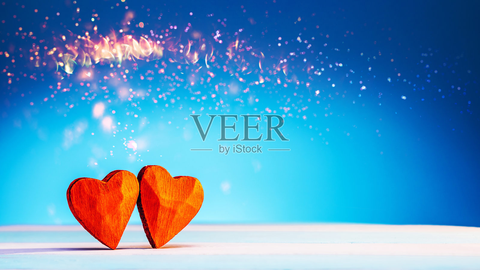 彩色条纹平台上的两个红色木制爱心，情人节极简概念照片摄影图片