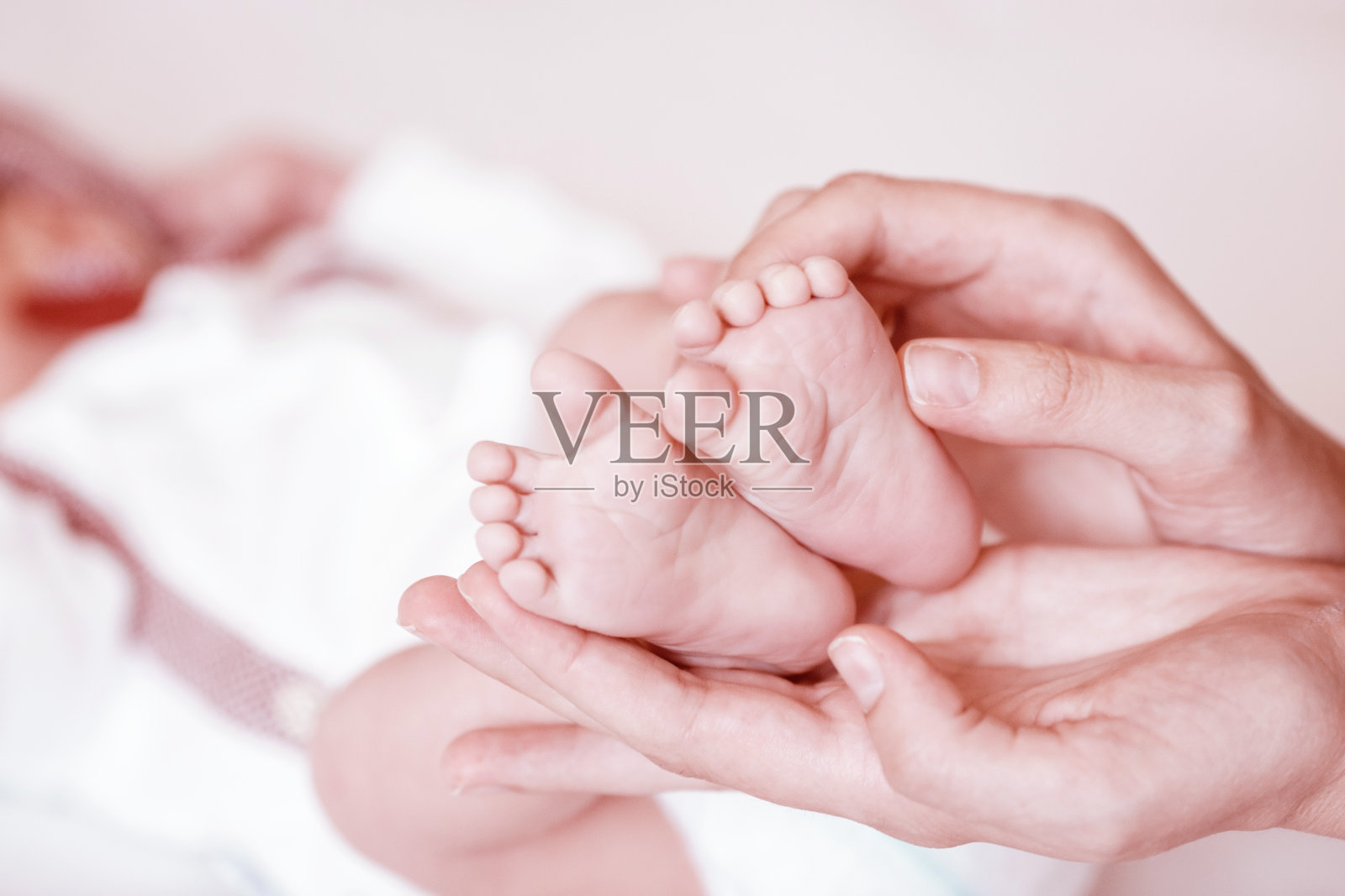女性手中新生婴儿的脚部特写照片摄影图片