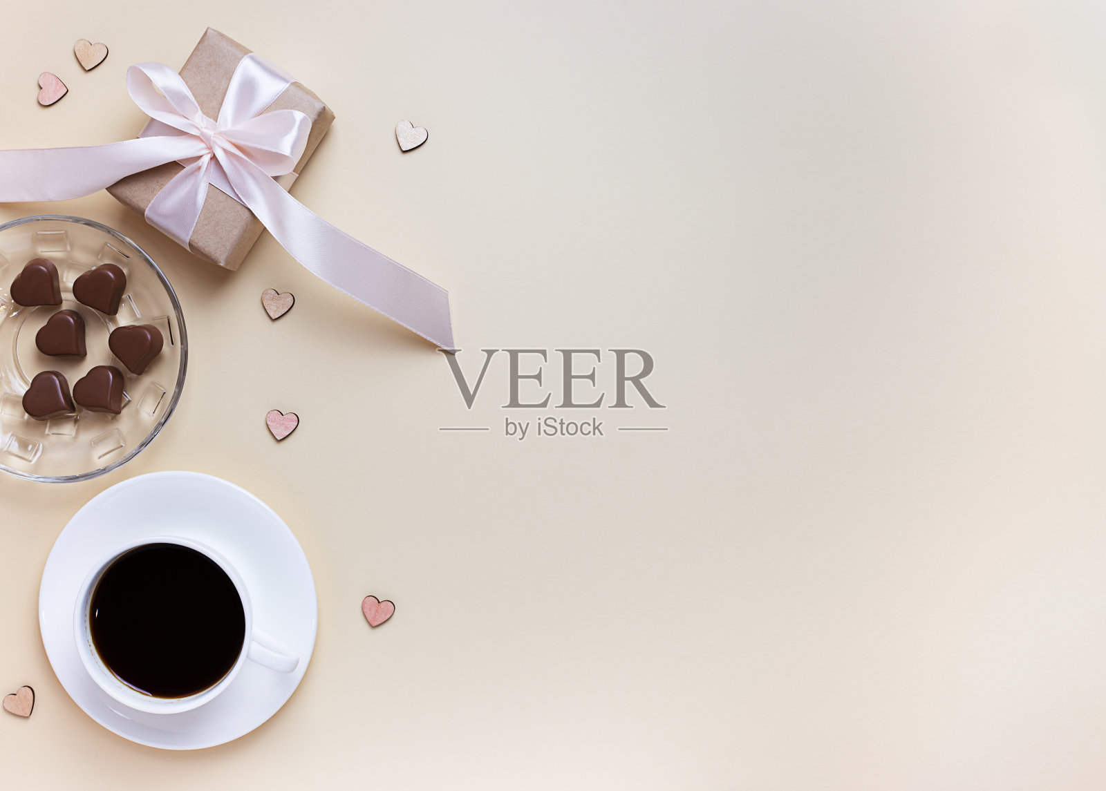 情人节的横幅。一杯咖啡，一个礼盒和一个在中性米色背景下的心形巧克力。照片摄影图片