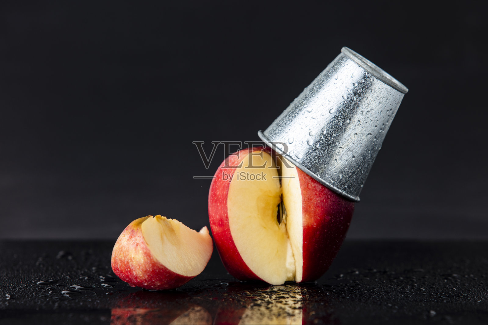 把苹果切成薄片，在上面放一个小金属桶照片摄影图片