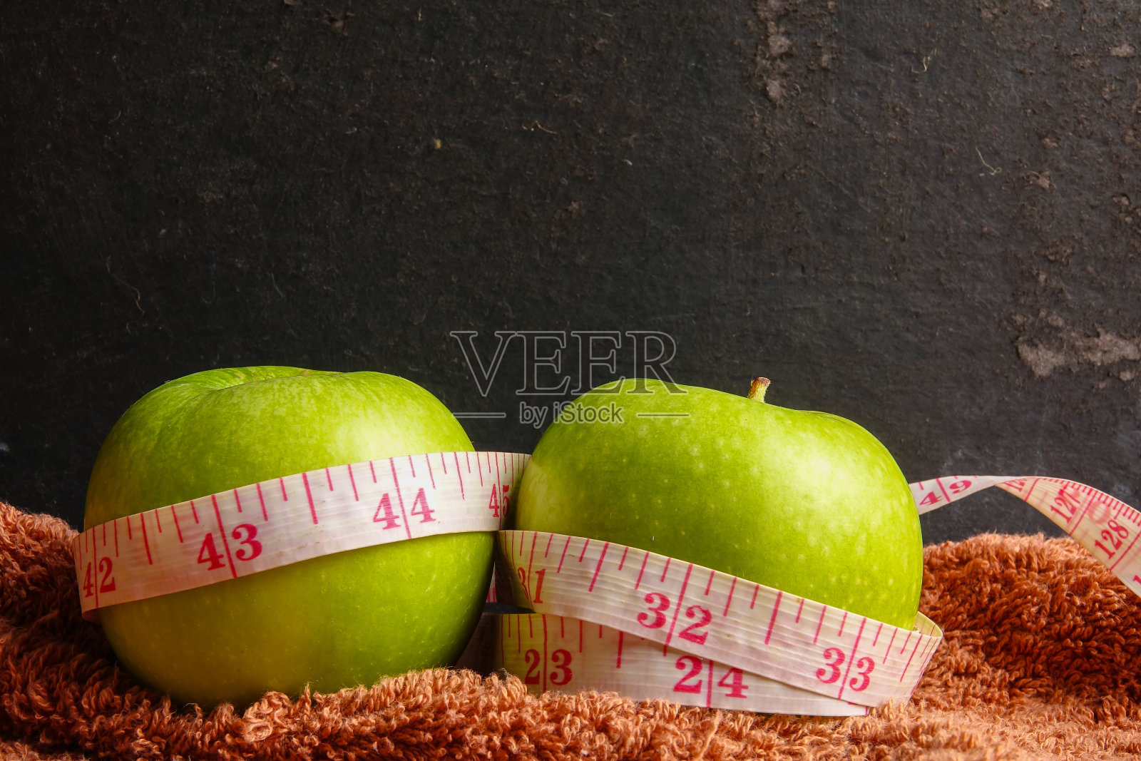 健康生活理念:青苹果和卷尺在黑色的乡村背景。有选择性的重点。照片摄影图片