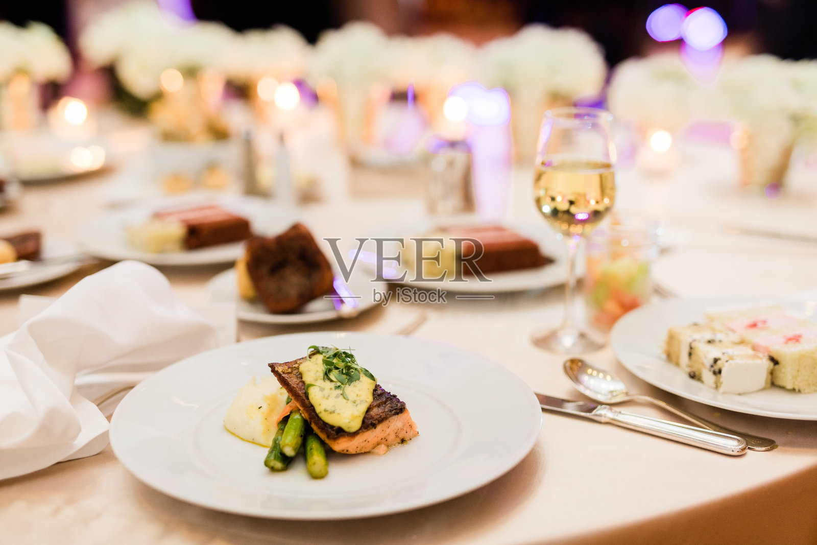 婚礼上的晚餐，以鲑鱼、芦笋和蛋糕为背景照片摄影图片