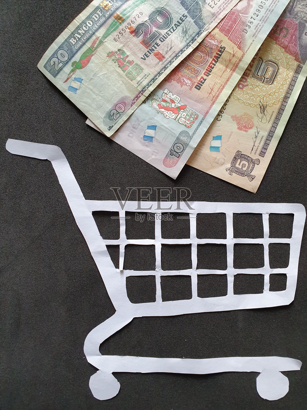 白色纸上的购物车和危地马拉的钱照片摄影图片