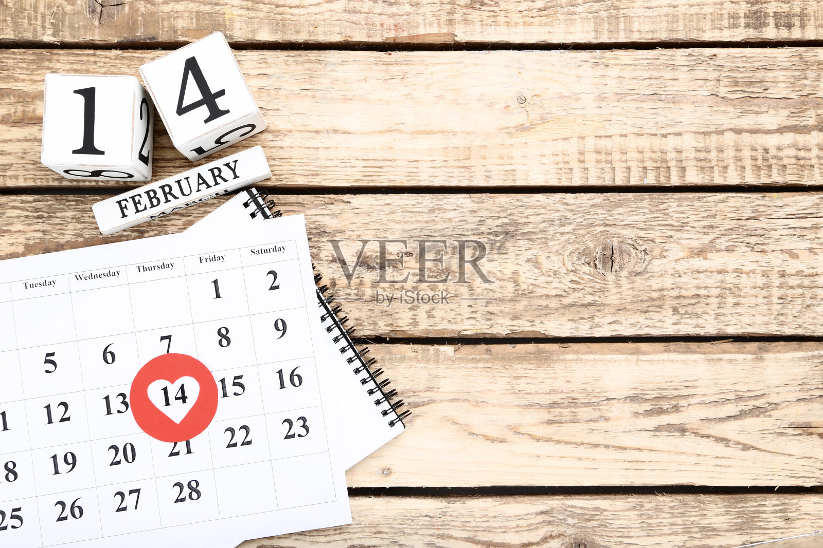 情人节日历和木制立方体在棕色的桌子上照片摄影图片