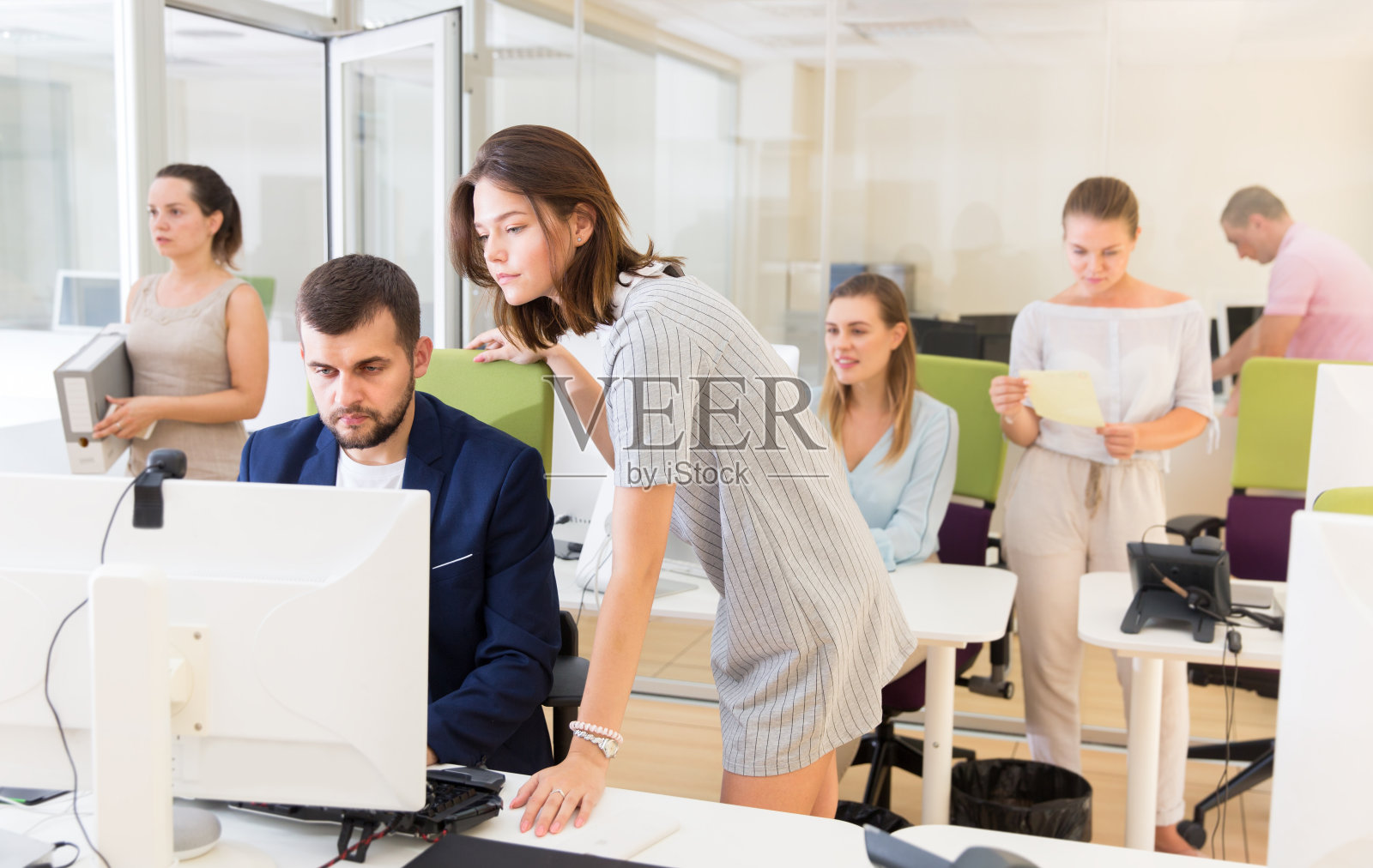 成功的女商人向电脑旁的男同事解释事情照片摄影图片