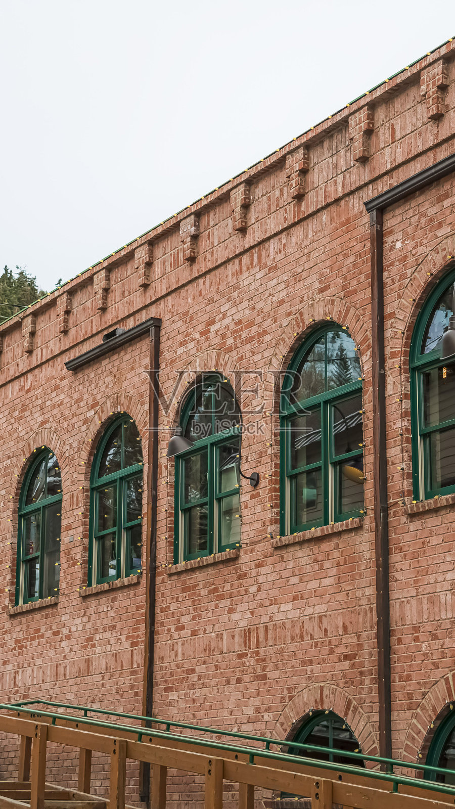 垂直框架餐厅外观在公园城市，红色的砖墙和绿色的拱形窗户照片摄影图片