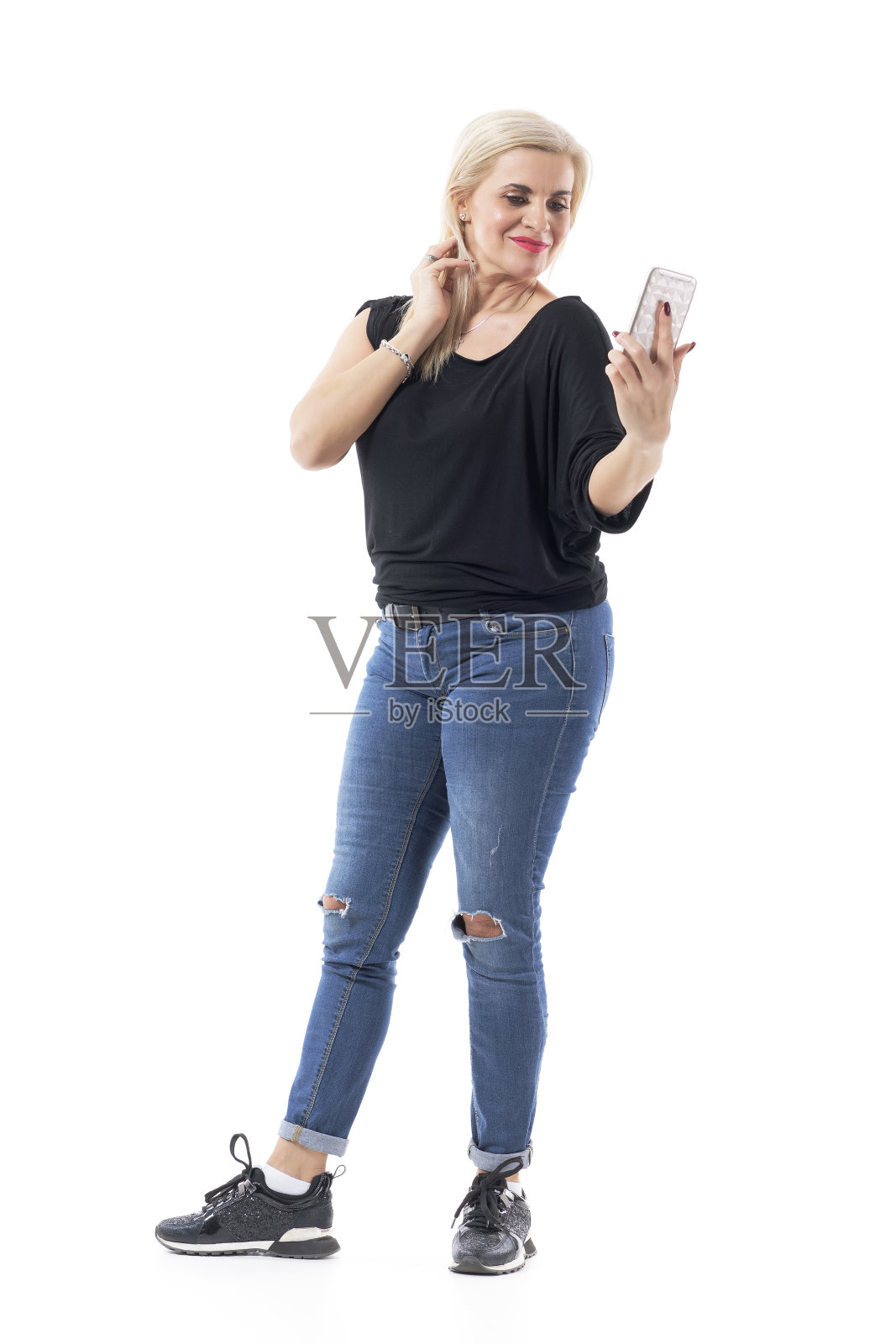 有远见的中年妇女手持和阅读手机短信的距离。照片摄影图片