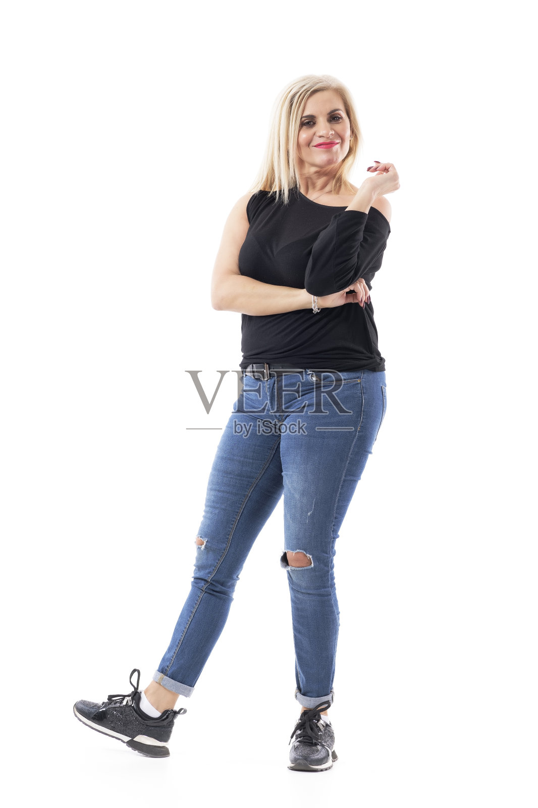 俏皮的中年有吸引力的女人在休闲衣服与金发看着相机和分析照片摄影图片