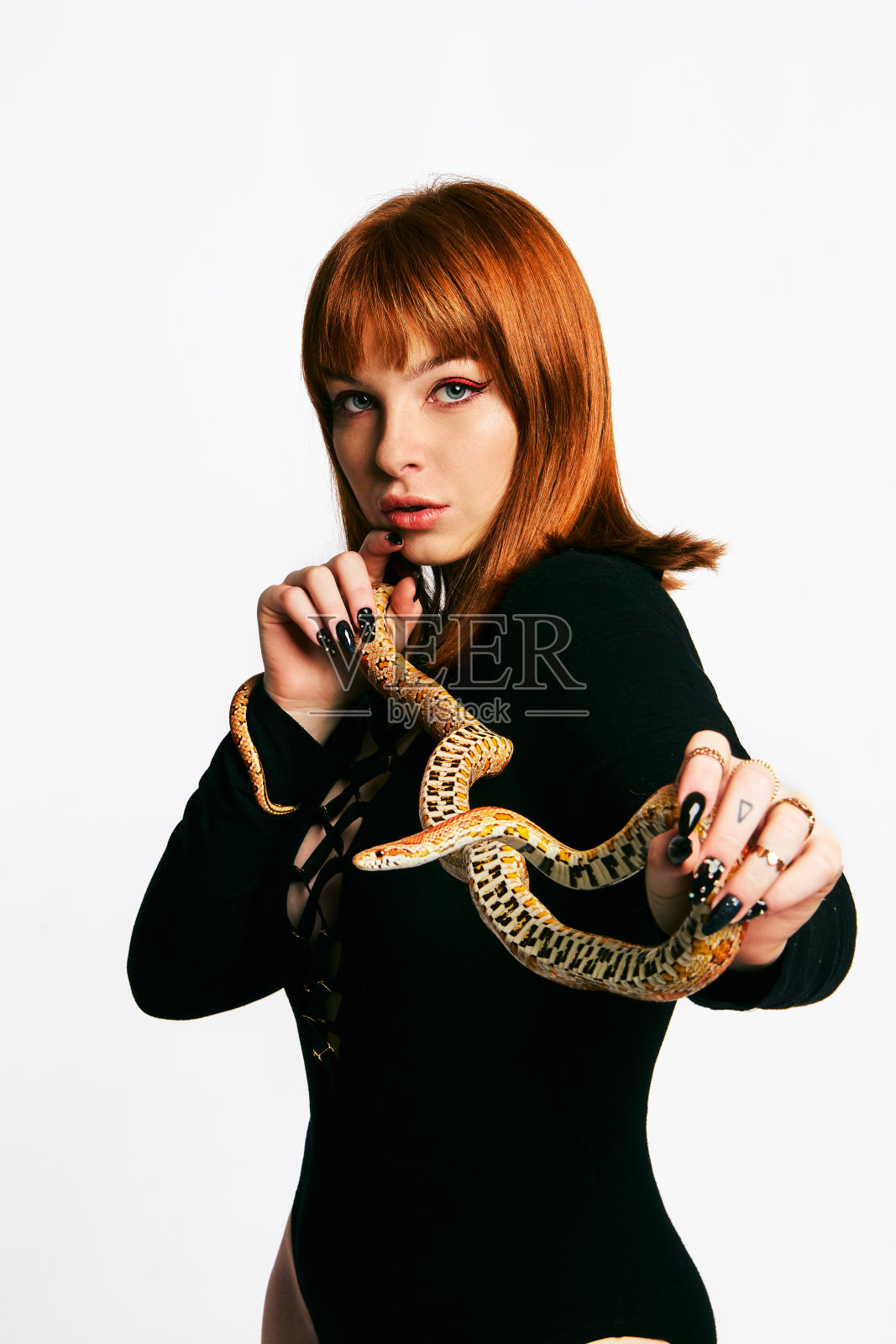 穿着黑色紧身衣的美女和蛇。姜模特女孩与时尚完美的化妆。照片摄影图片