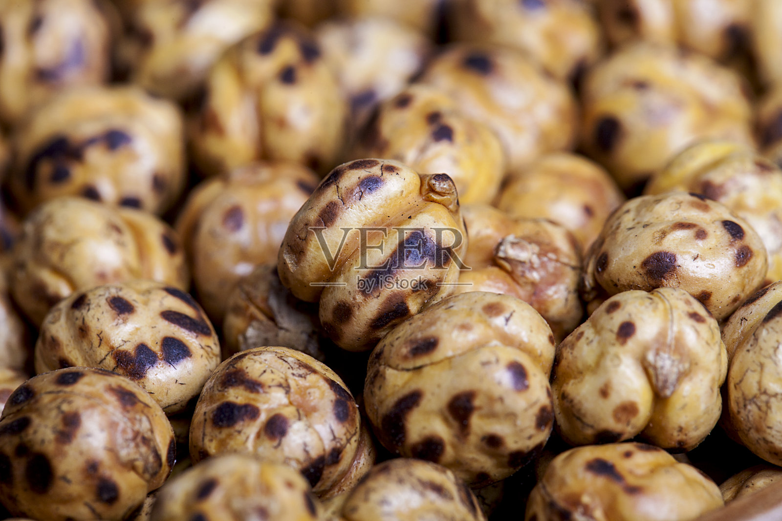 在木桌上的碗里烤干鹰嘴豆。照片摄影图片