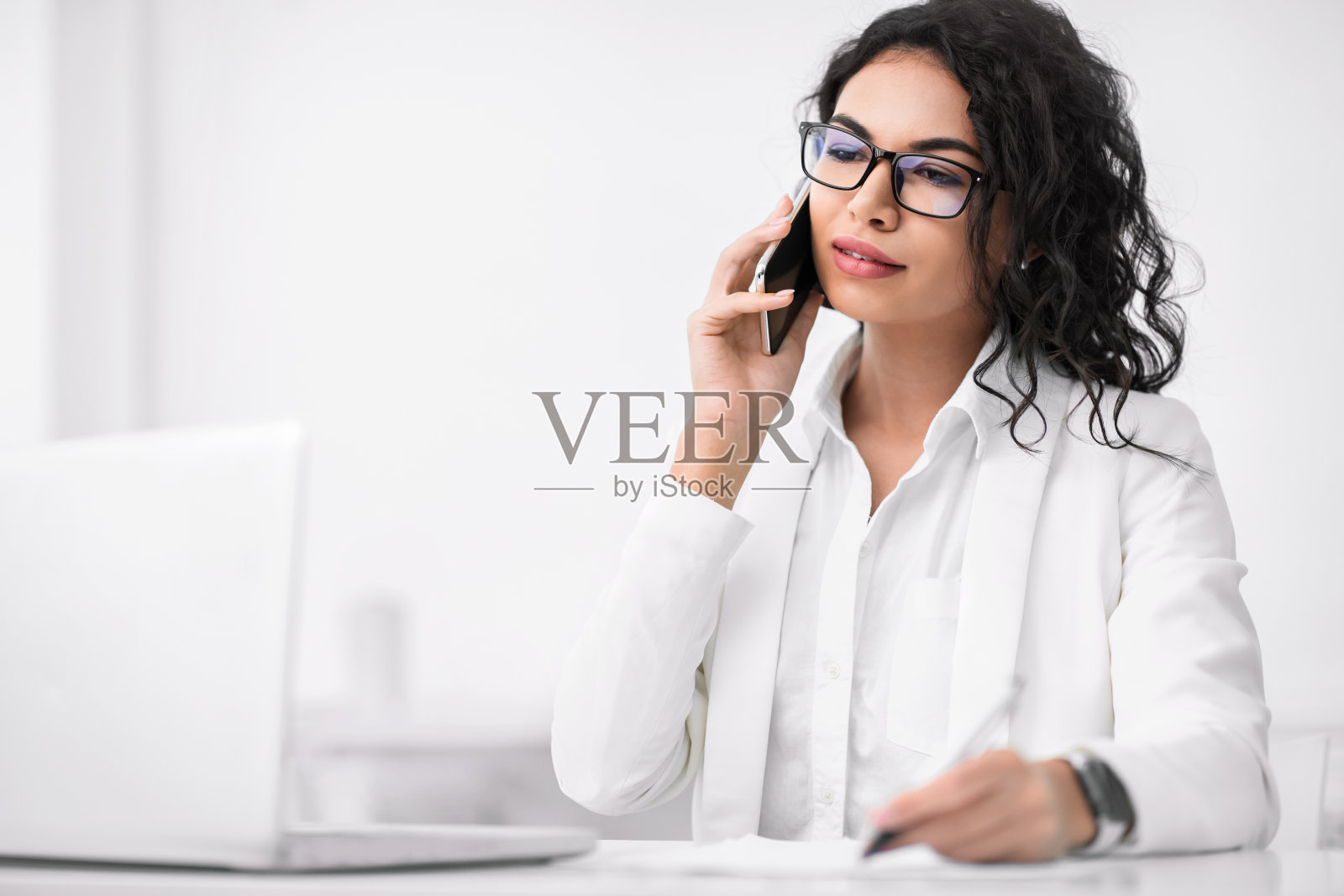 用手机交谈的沉思的西班牙裔女商人照片摄影图片