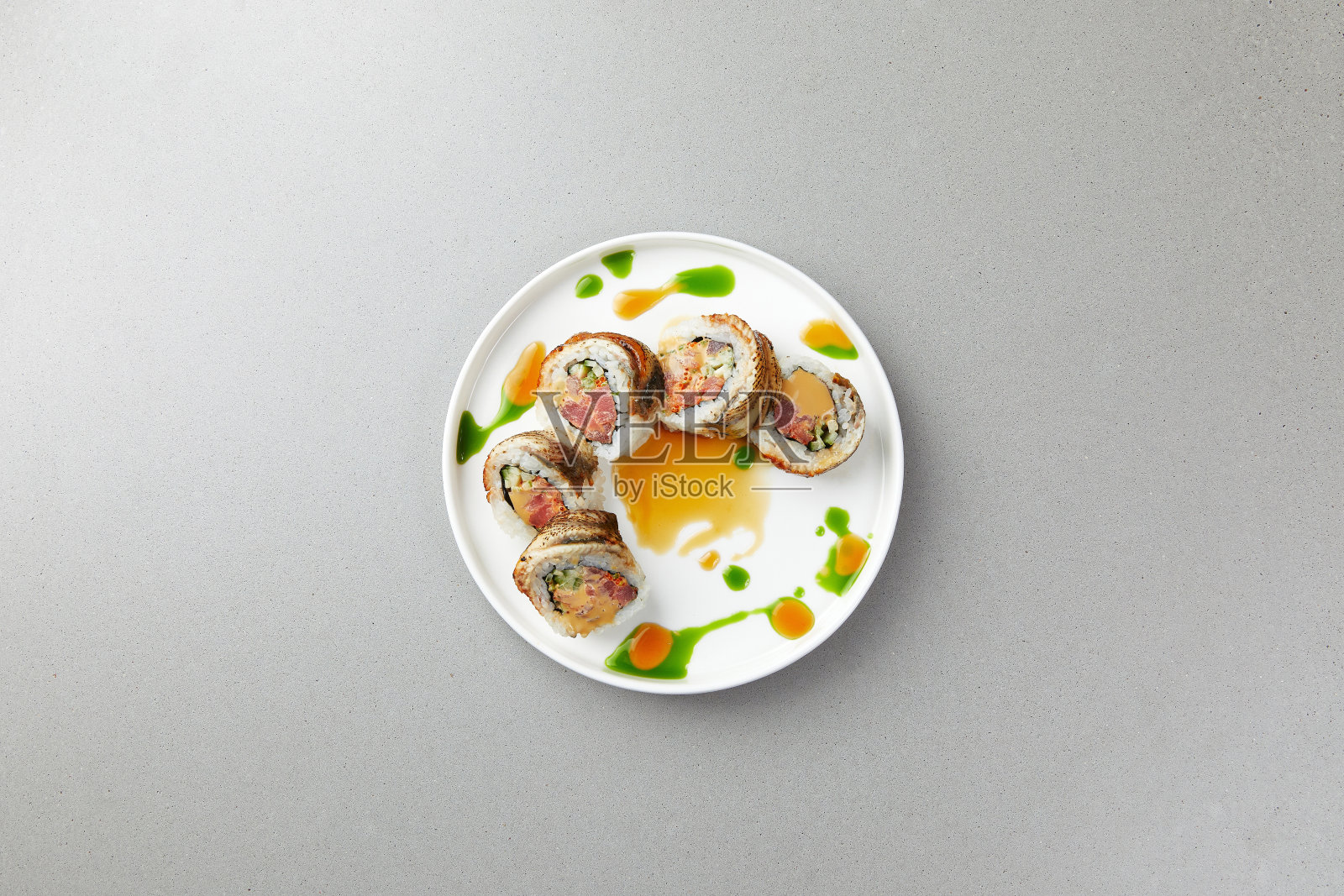 寿司配以鲑鱼、绿藻、鱼卷淋上酱料，再加上香料照片摄影图片