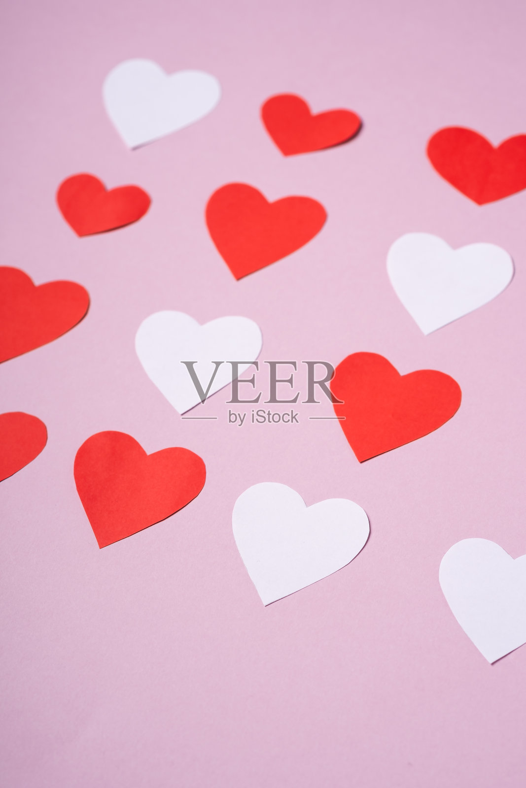 红白手工纸心情人节在粉色背景上，角度观，选择性聚焦照片摄影图片