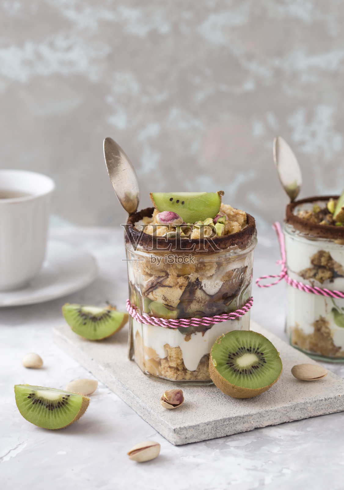 杯装猕猴桃冻糕。酸奶，格兰诺拉麦片和水果。健康的零食或早餐。照片摄影图片