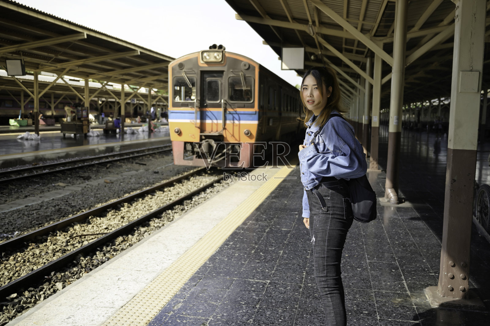 亚洲女性独自在火车站旅行。照片摄影图片