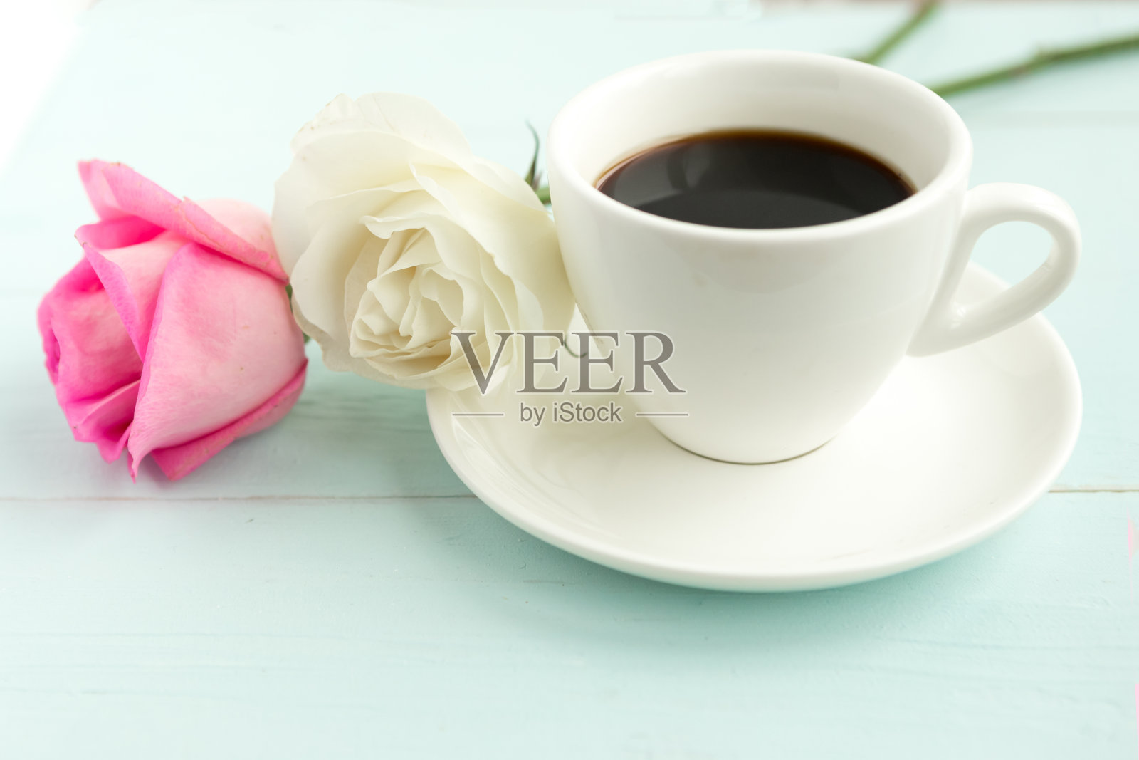 咖啡杯和玫瑰放在木桌上照片摄影图片
