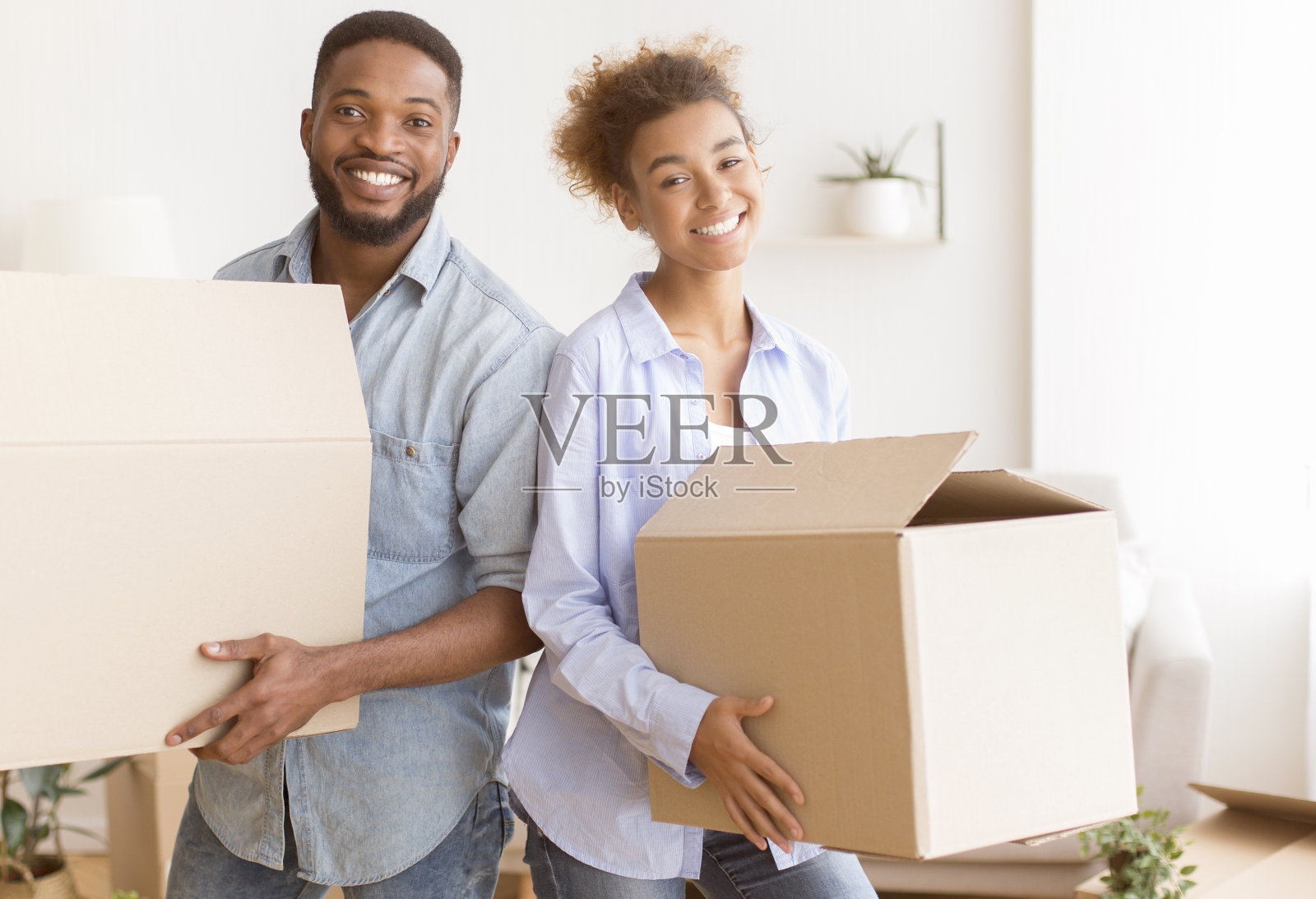 新公寓里夫妻拿着箱子照片摄影图片