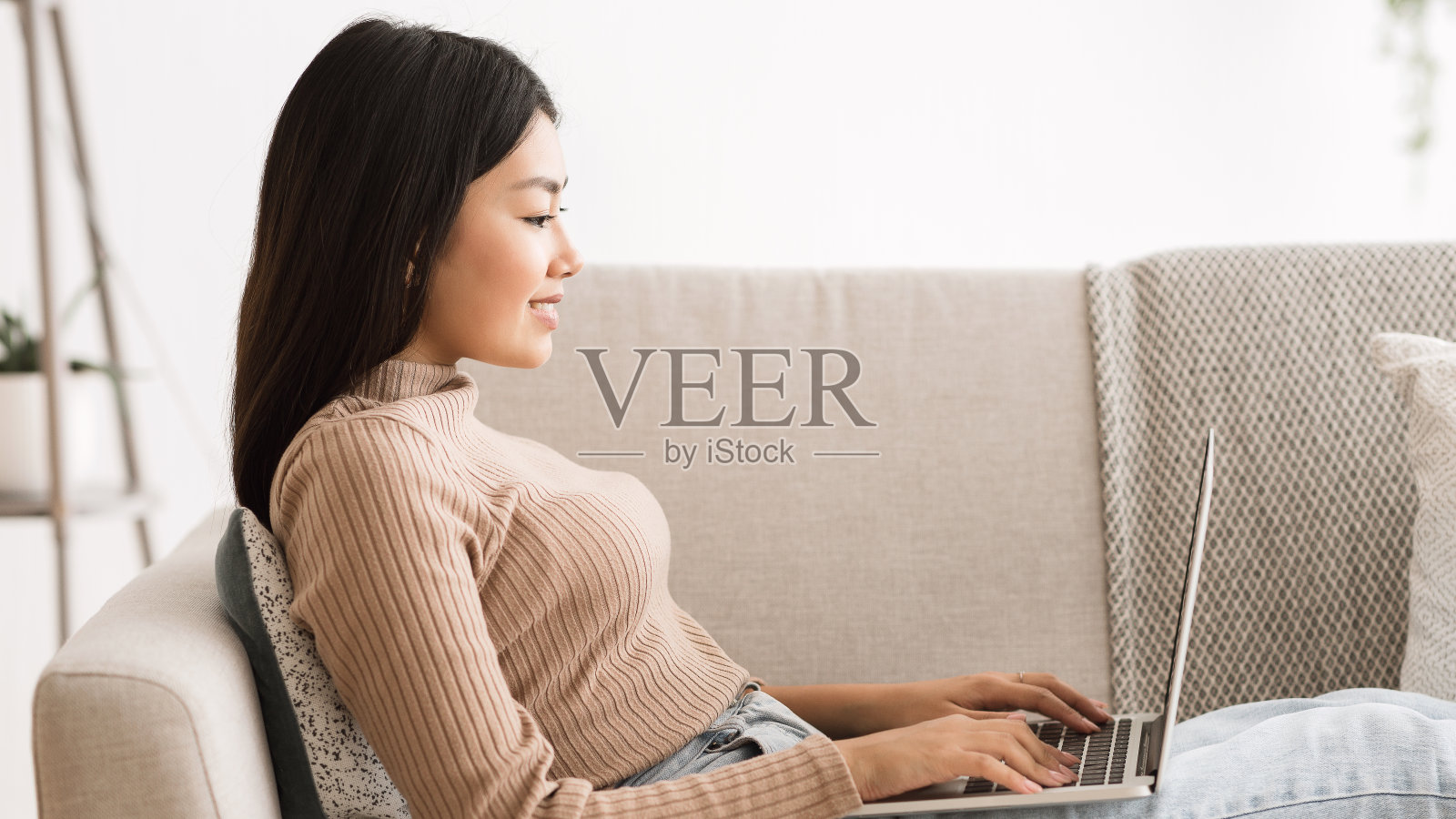 年轻女子在家沙发上用笔记本电脑上网照片摄影图片