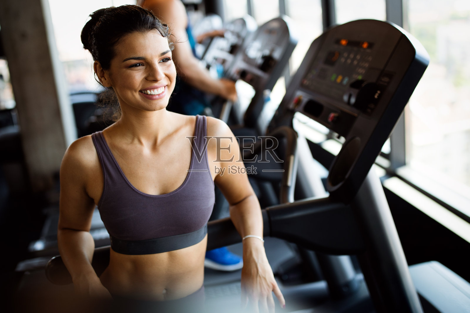 一群年轻人在现代体育馆里的跑步机上跑步照片摄影图片