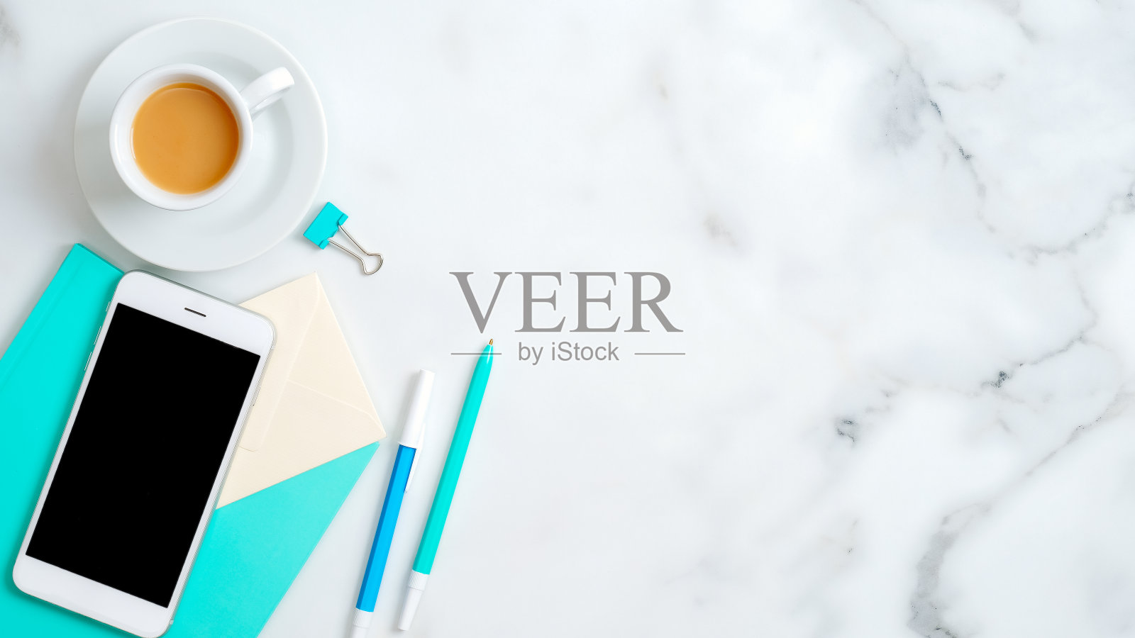 平躺女性的家庭办公桌子，智能手机空屏幕模型，薄荷笔记本，文具，时尚的配件，咖啡杯的大理石背景。顶部视图与复制空间。照片摄影图片