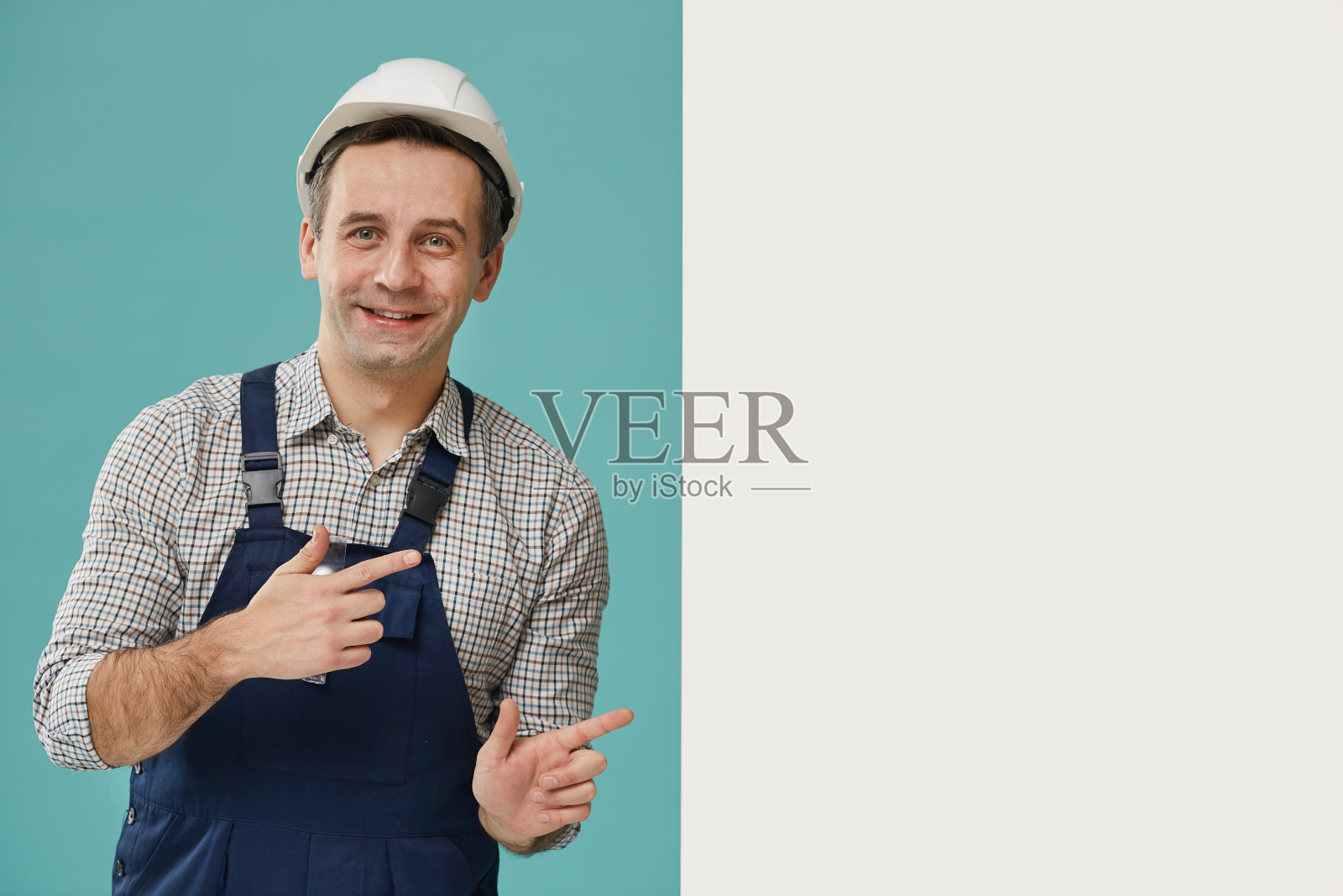 微笑的工人指着空白标志照片摄影图片