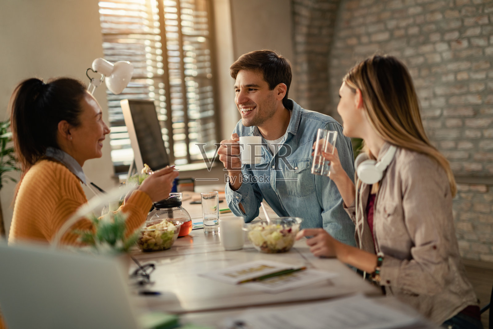 愉快的商人在午餐休息时间和同事聊天。照片摄影图片