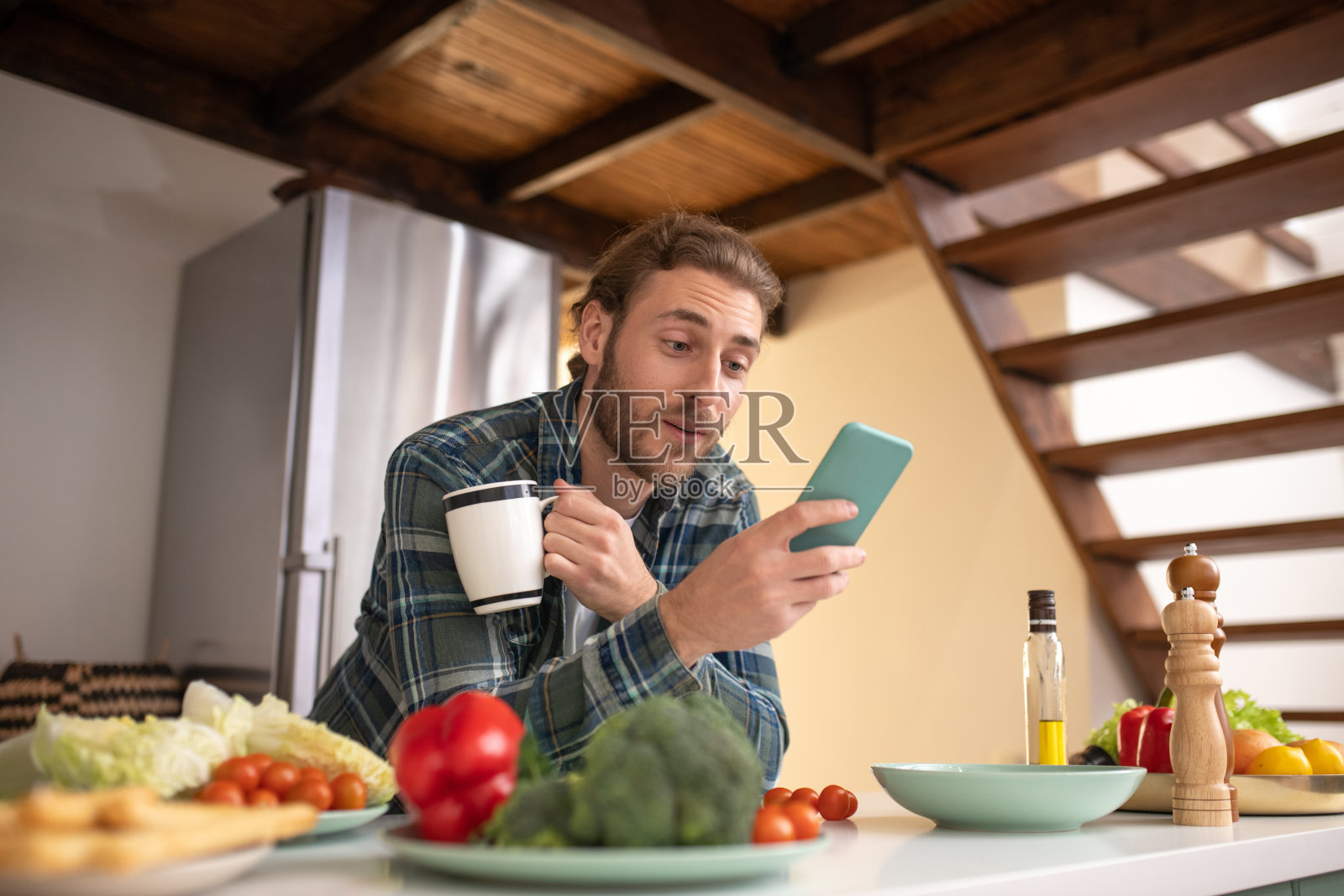 惊讶的男人一边喝茶一边做饭照片摄影图片