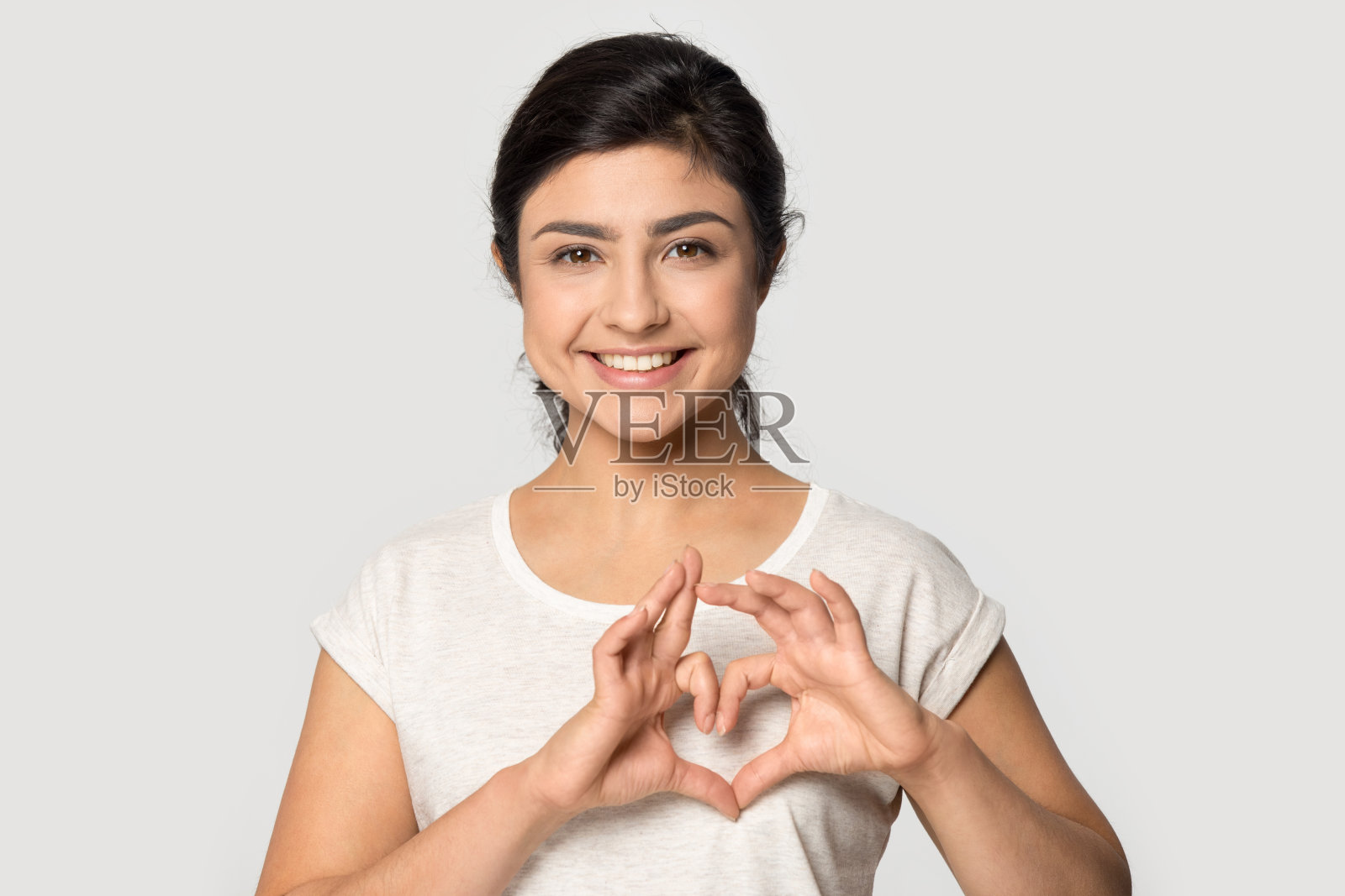 快乐的年轻印度民族妇女使心形手势符号。照片摄影图片