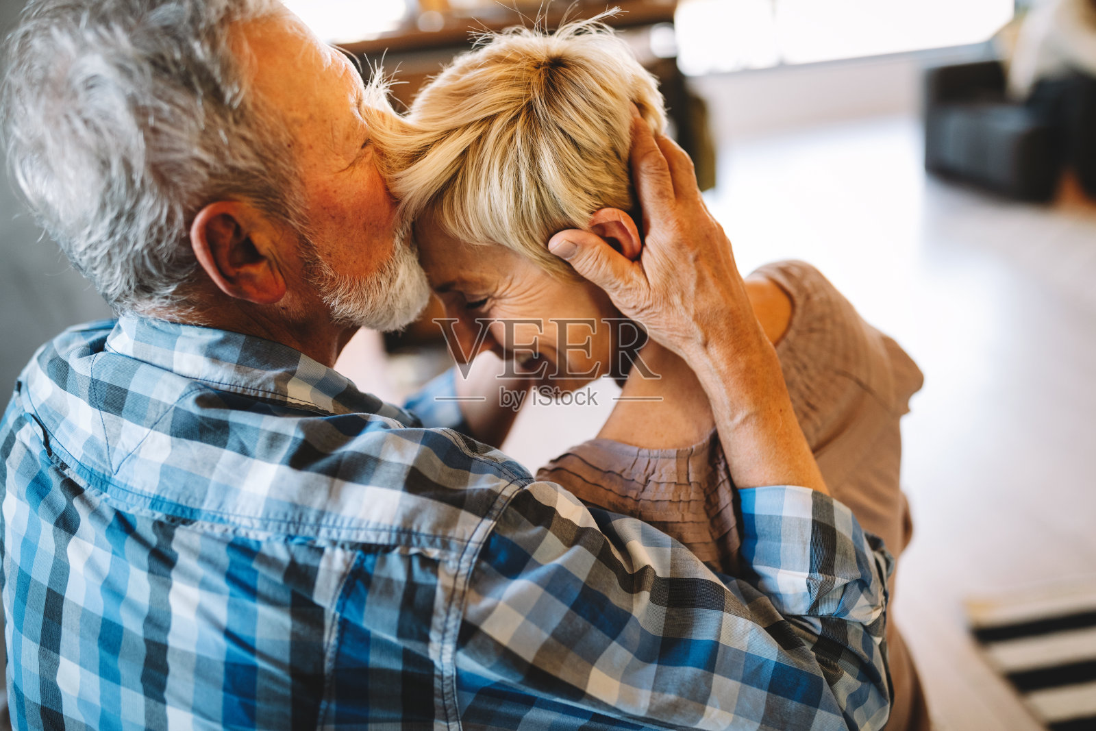 幸福微笑的老年夫妇在家里一起拥抱照片摄影图片