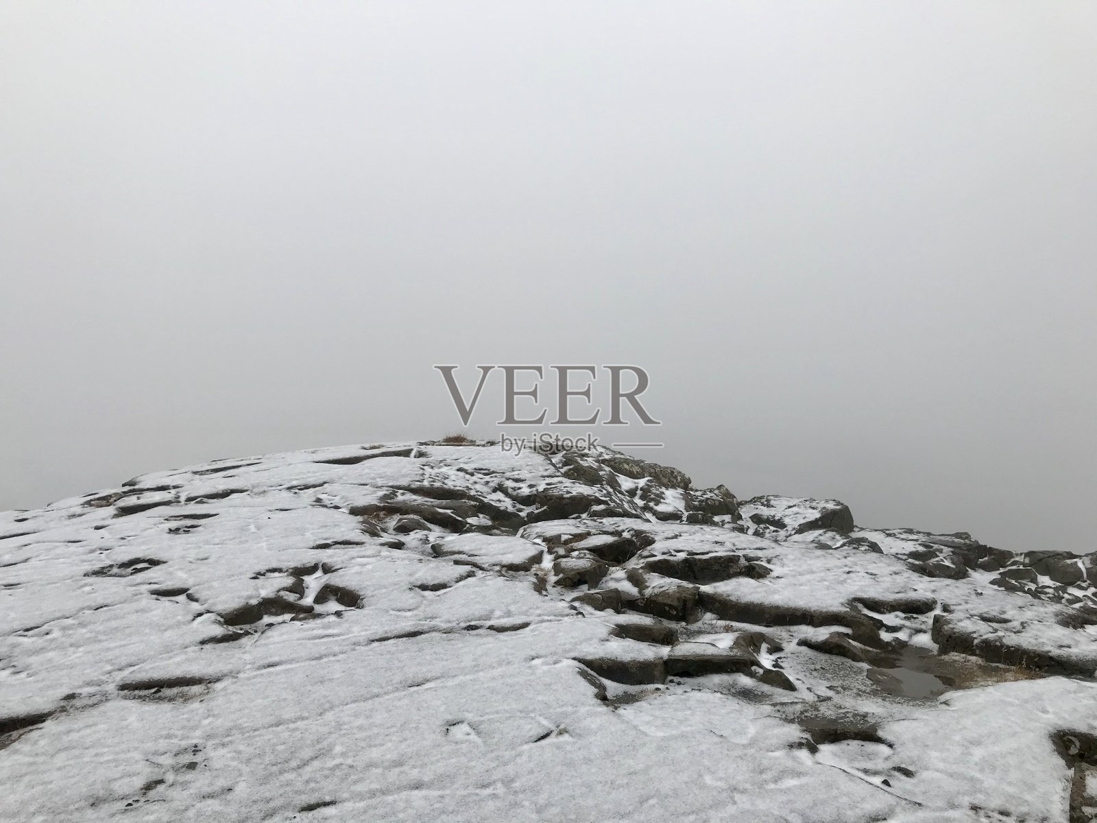 在冰岛的Gullfoss瀑布悬崖上感受世界的尽头:结霜的雾状的冬季景观与岩石，瀑布在背景和冰雪覆盖的冰岛风景在11月照片摄影图片