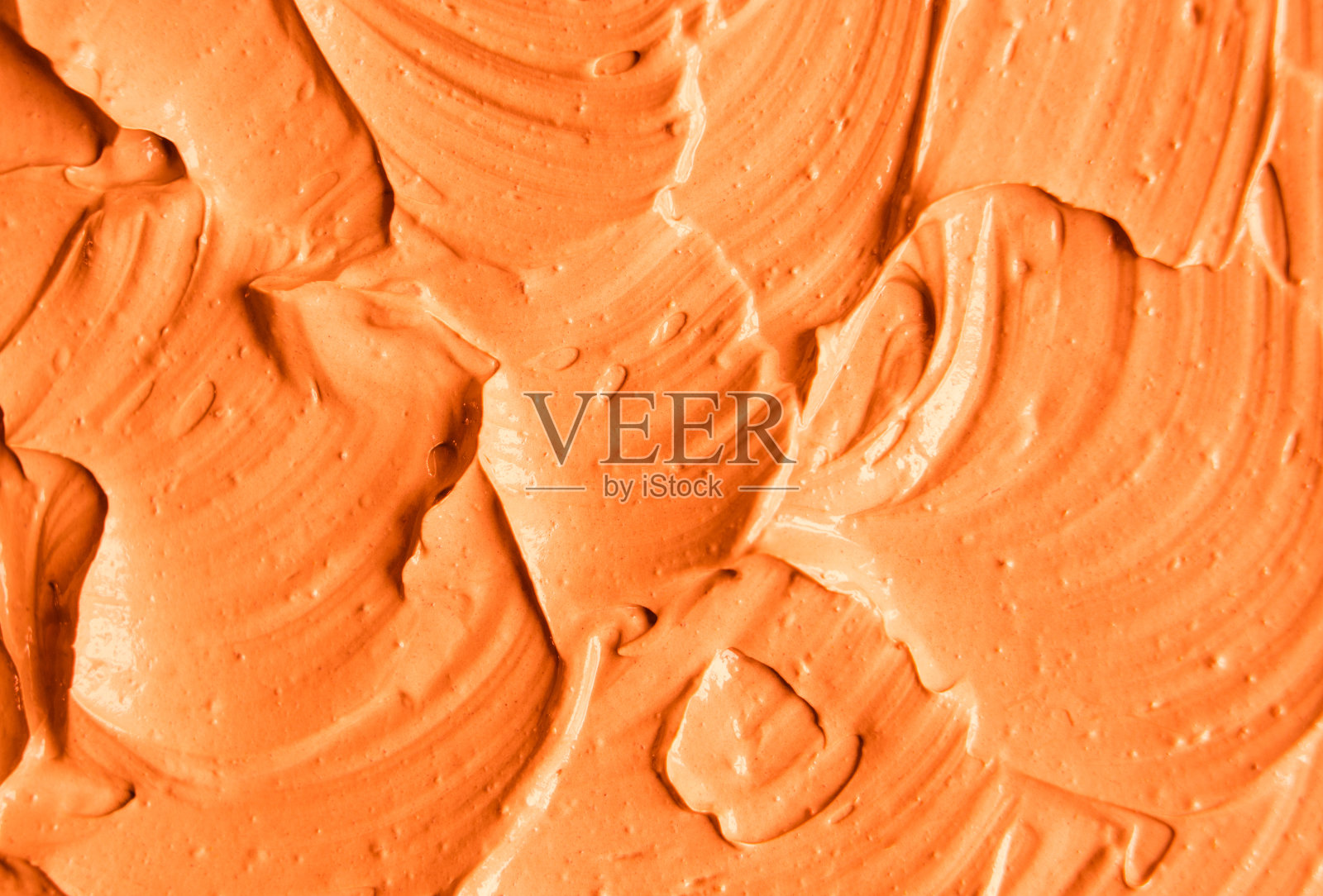 橙色面膜(南瓜霜、身体磨砂膏)纹理近距离，选择性聚焦。抽象的背景与画笔笔触。照片摄影图片