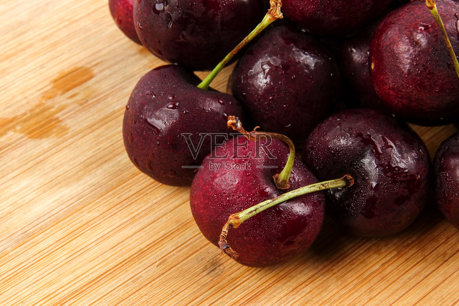 木制背景上的甜红樱桃。照片摄影图片